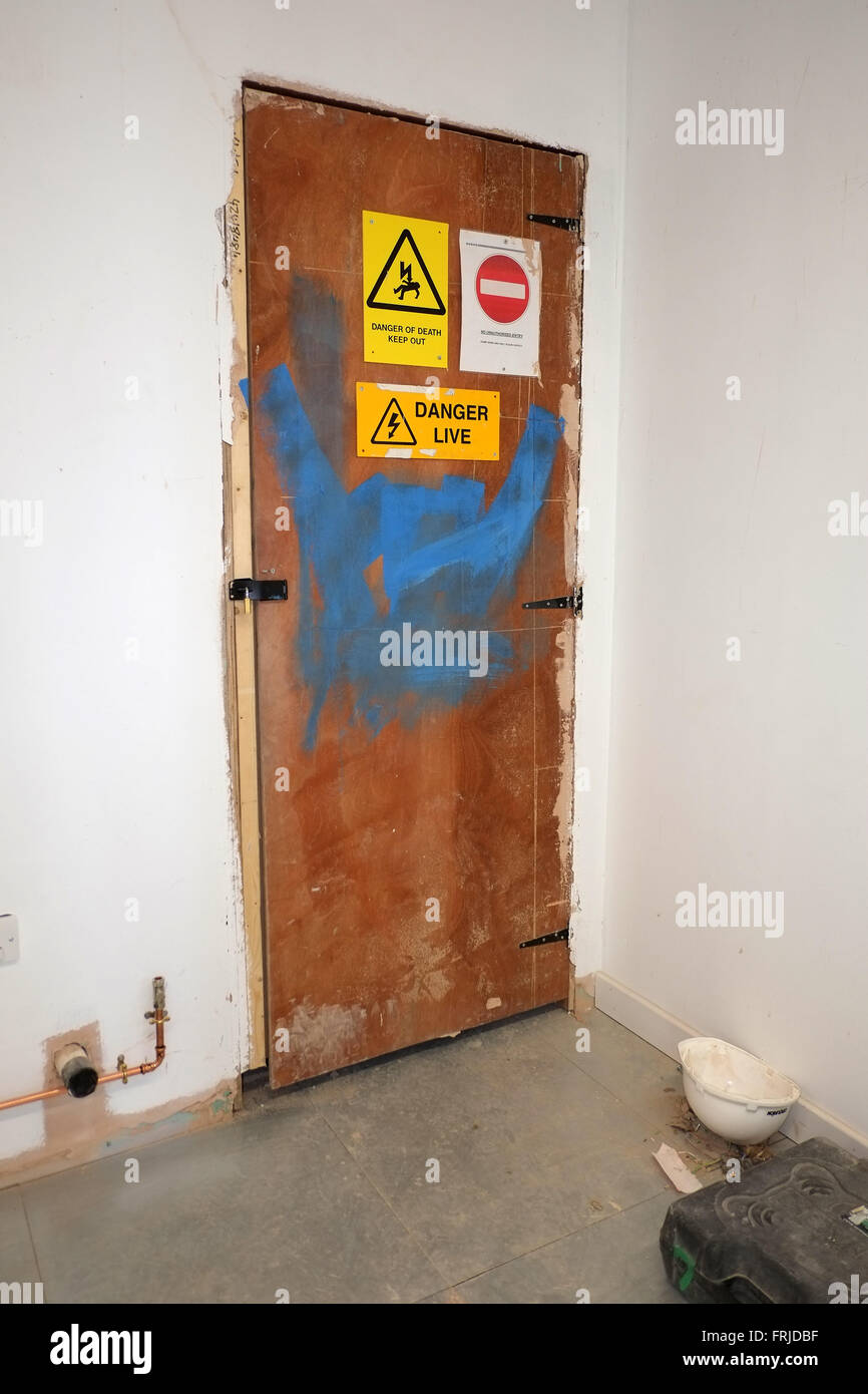 Temporary door to an Electrical switch room, with danger signs, on a near to complete construction project. March 2016 Stock Photo