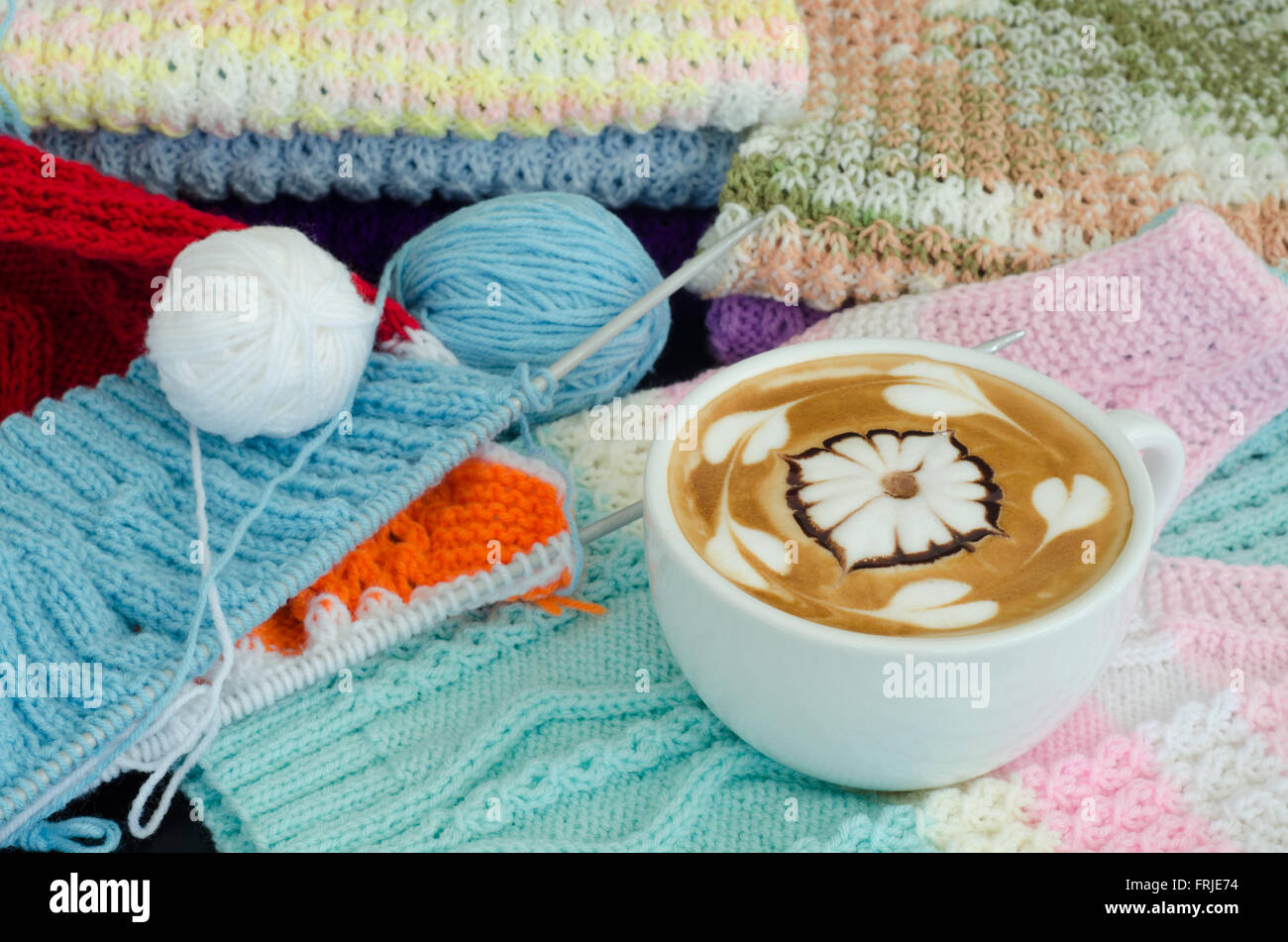 A cup of latte art on a knitted vest background Stock Photo