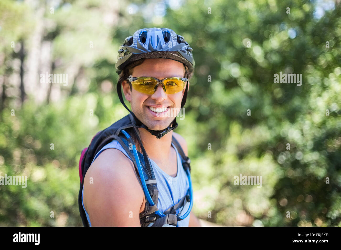 Portrait of smiling man wearing helmet at forest Stock Photo