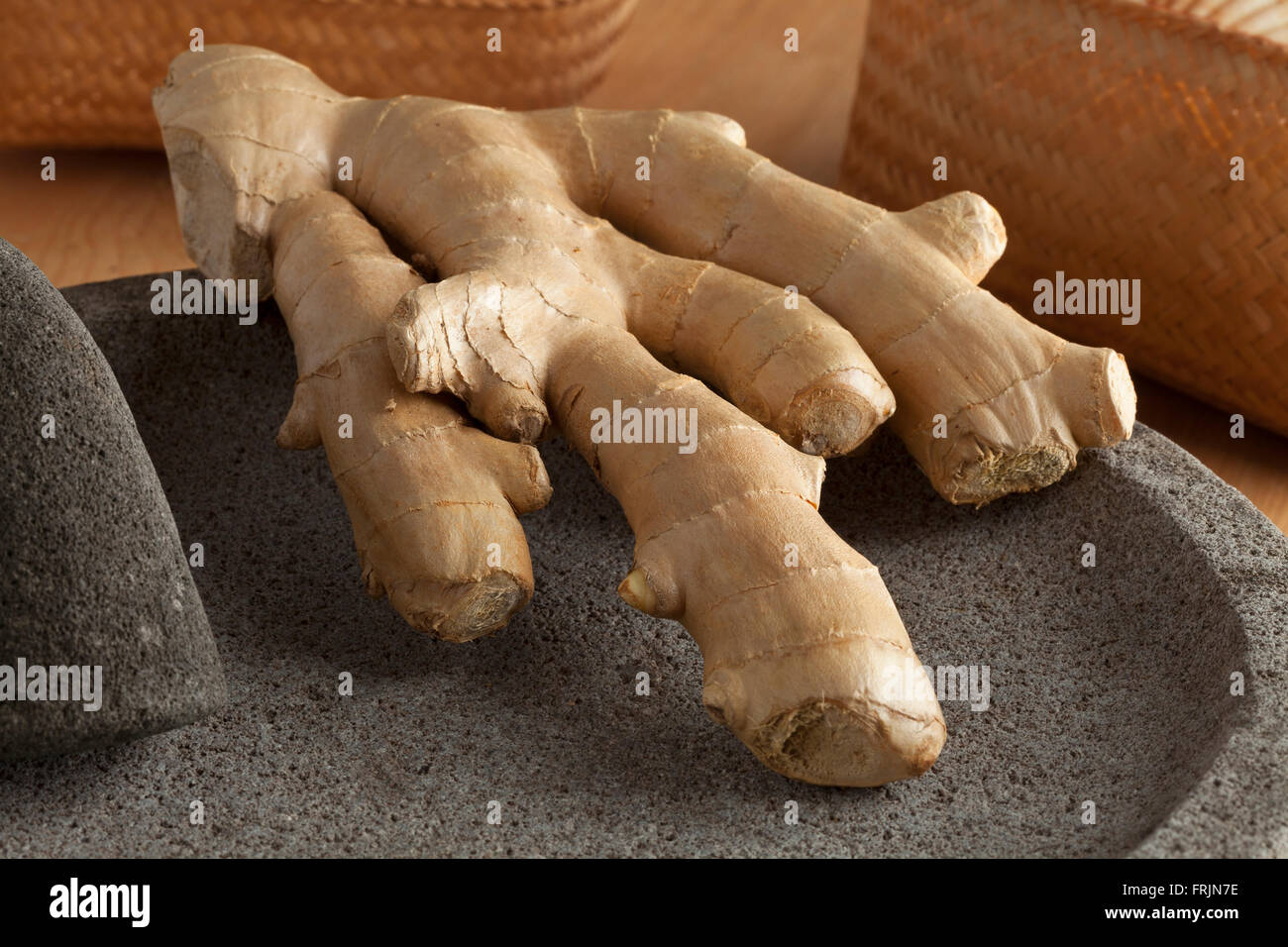 Fresh ginger rhizome close up at a pestle and mortar Stock Photo
