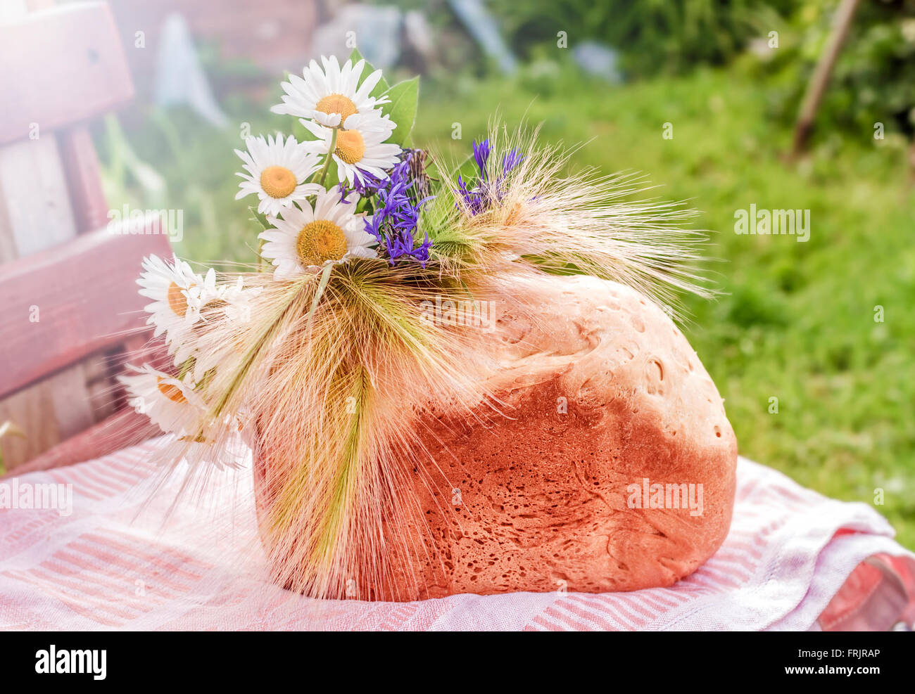 Freshly baked white bread with camomilles in sunny light Stock Photo