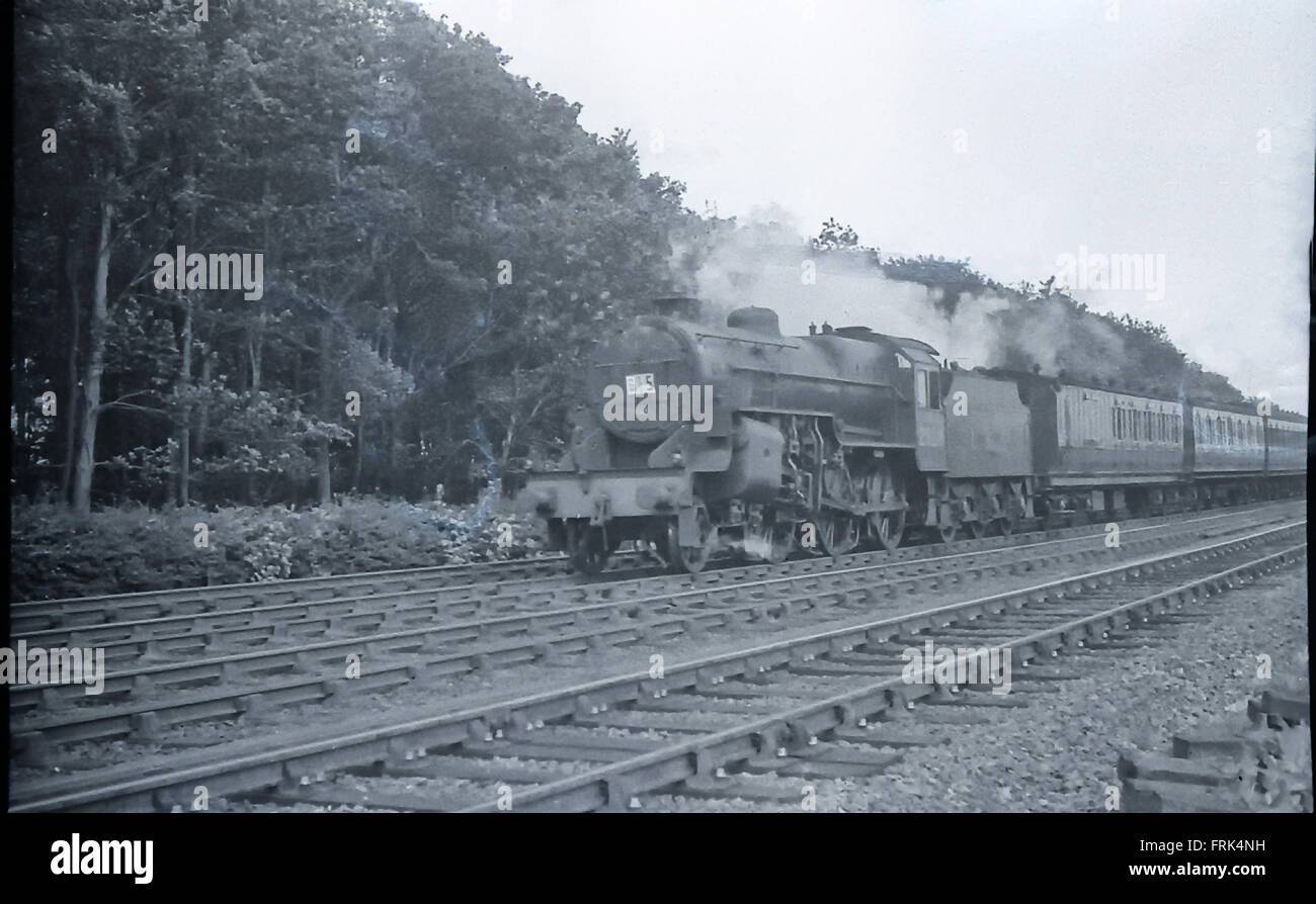 2-6-0 Crab (possibly No.2828 or 2838) with LNWR carriage at front of train Stock Photo