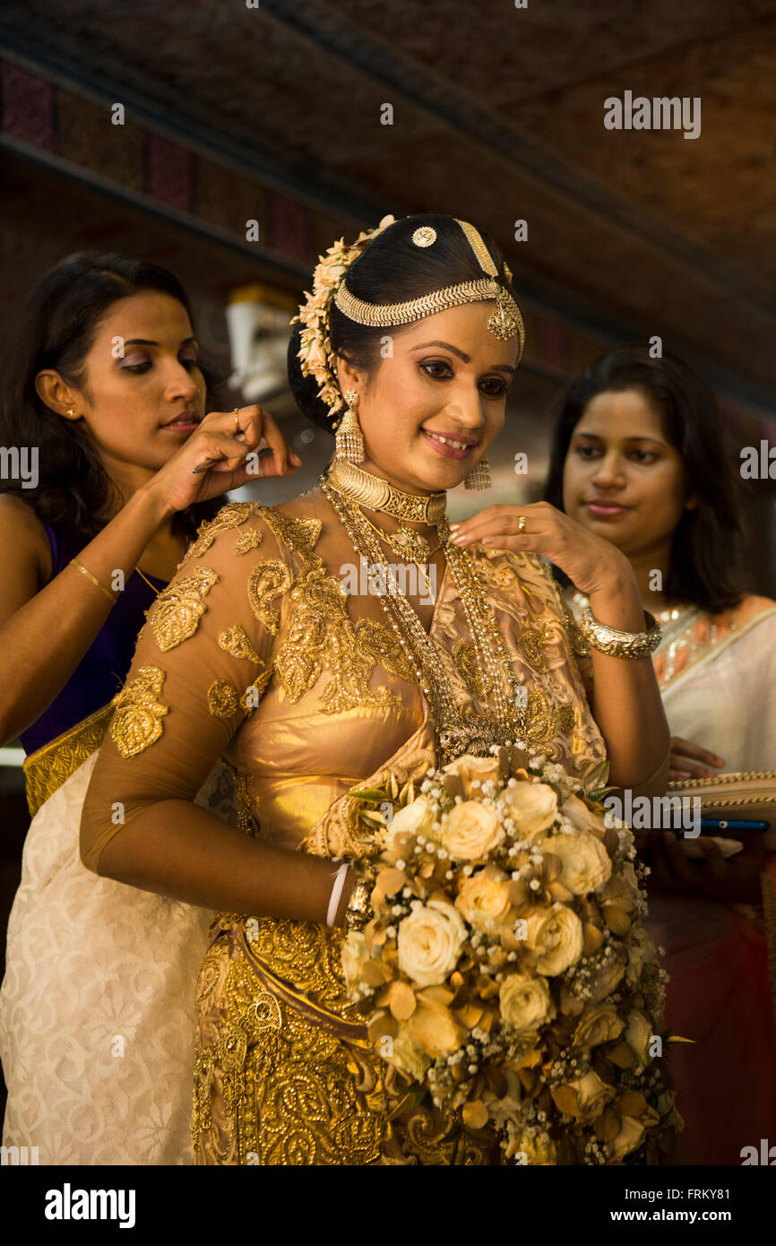 Sri Lanka, Colombo, weddings, bride being prepared for wedding blessing at Gangaramaya Temple, Stock Photo