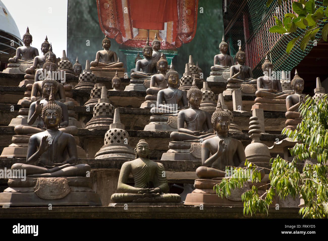 Sri Lanka, Colombo, Gangaramaya Temple, multiple Buddha figures around central dagoba Stock Photo