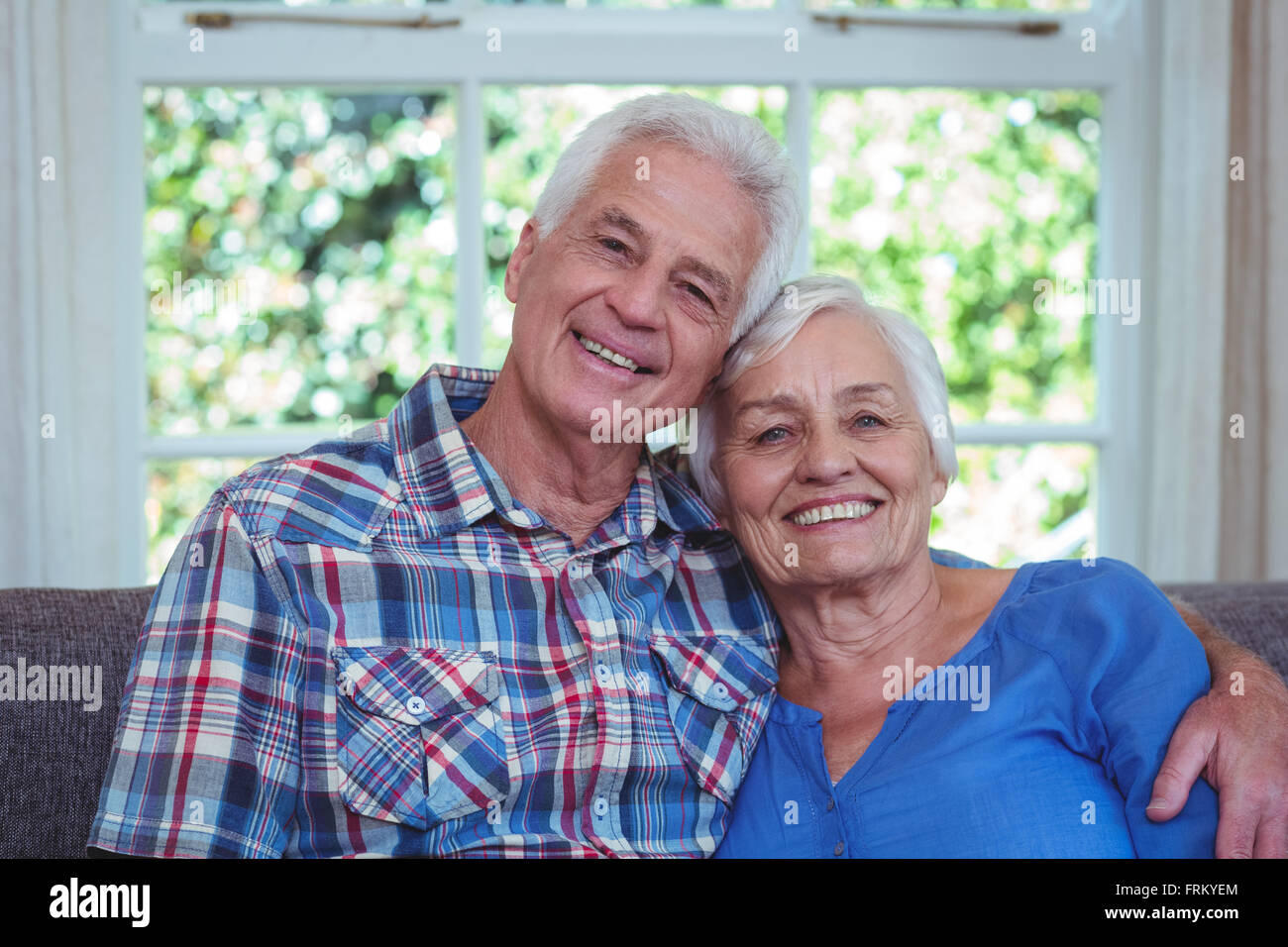 Happy senior couple sitting on sofa Stock Photo - Alamy
