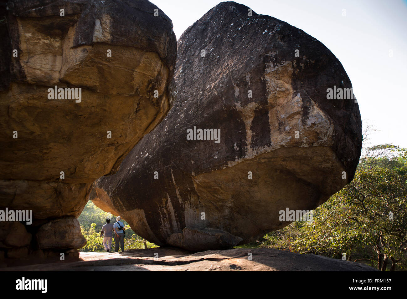 Sri Lanka, Anuradhapura, Vessagiriya, ancient forest monastery, rock caves tourist with guide amongst boulders Stock Photo