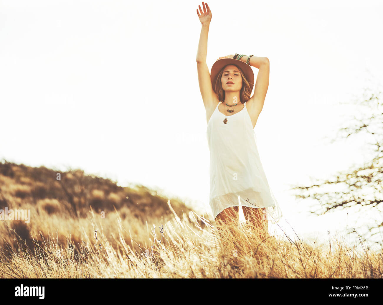 Fashion Lifestyle. Fashion Portrait of Beautiful Young Woman Outdoors. Soft warm vintage color tone. Artsy Bohemian Style. Stock Photo