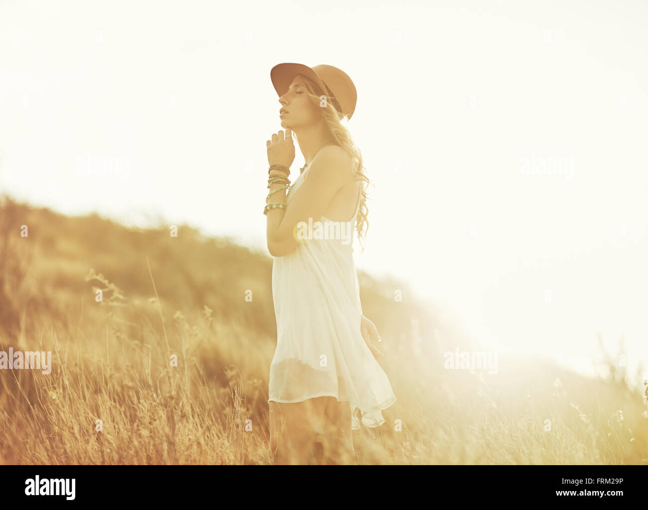 Fashion Lifestyle. Fashion Portrait of Beautiful Young Woman Outdoors. Soft warm vintage color tone. Artsy Bohemian Style. Stock Photo