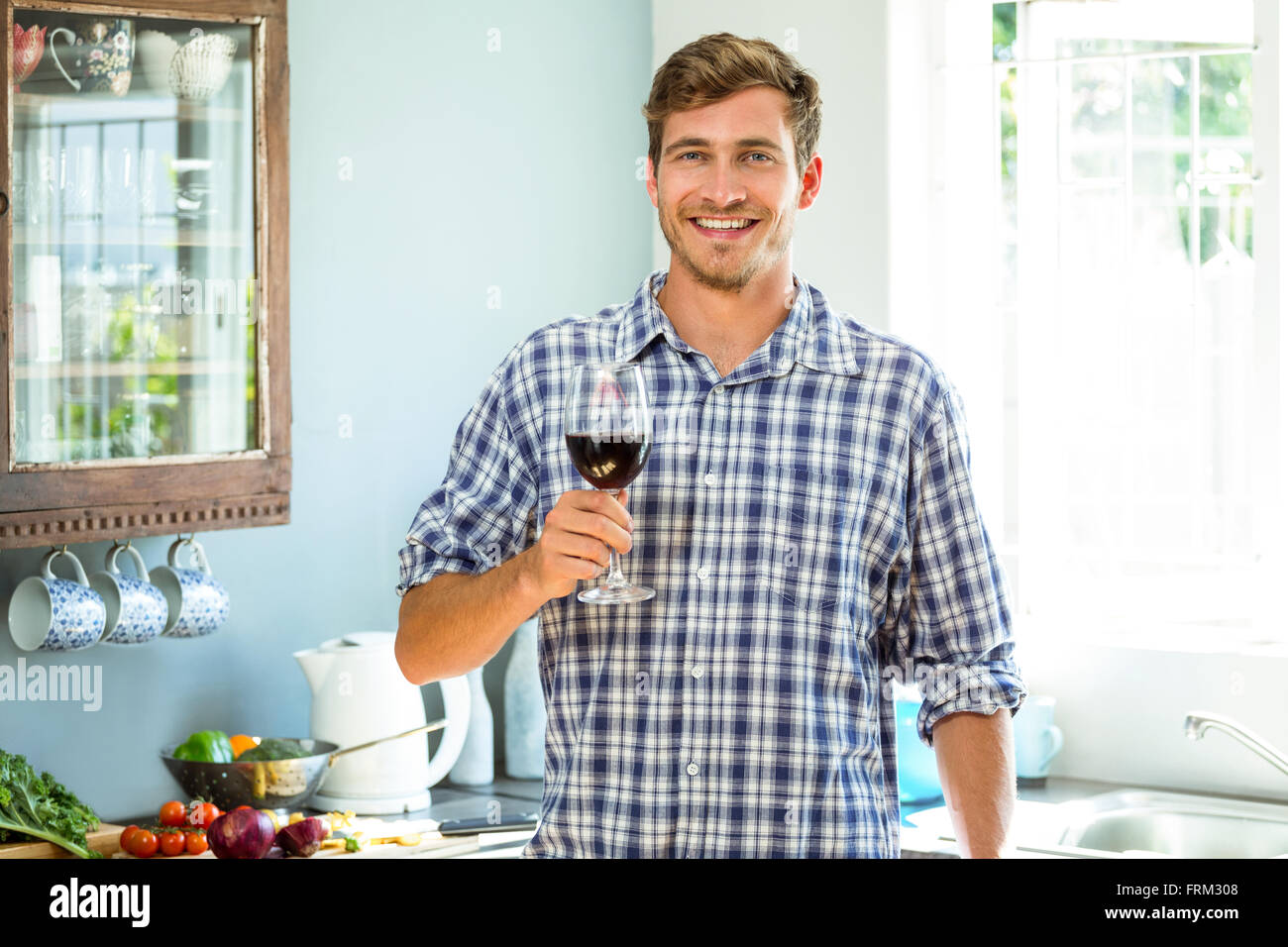 Young man holding a glass of red wine Stock Photo