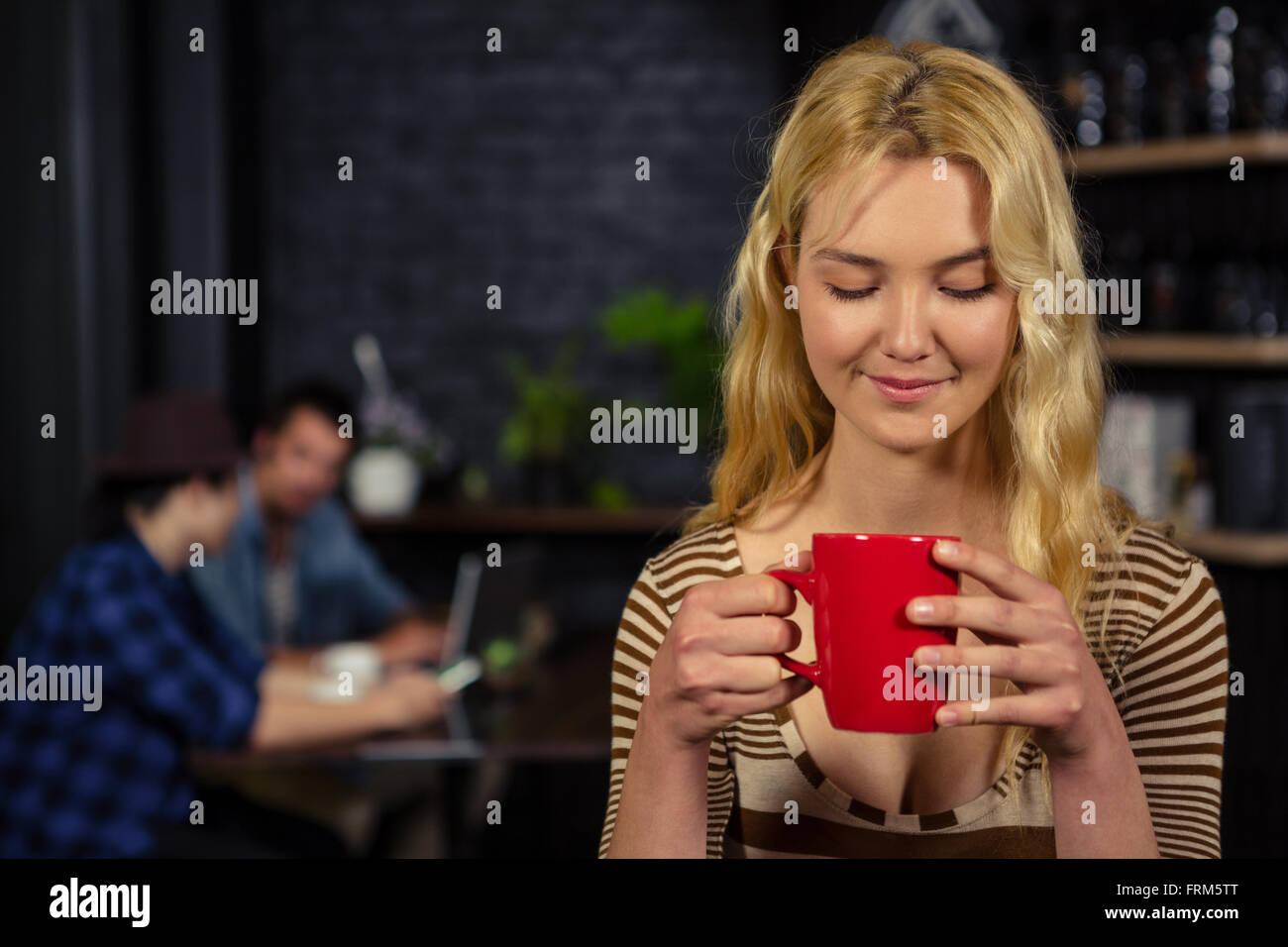 Blonde woman drinking a cup of coffee Stock Photo - Alamy