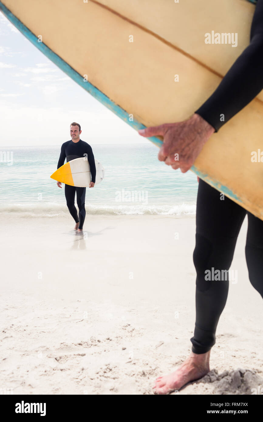 Man walking with surfboard on the beach Stock Photo - Alamy