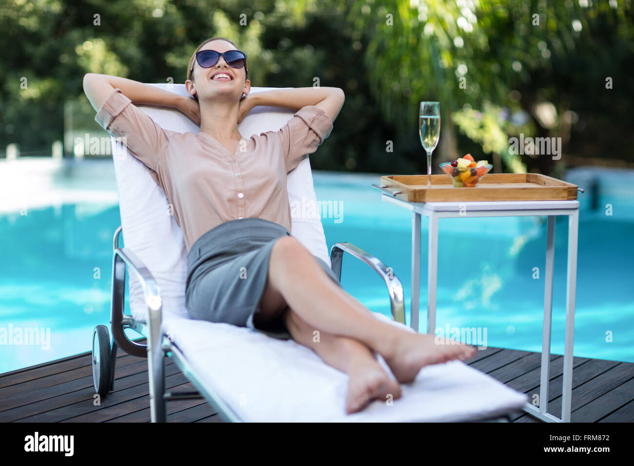 Happy businesswoman relaxing in sun lounger Stock Photo