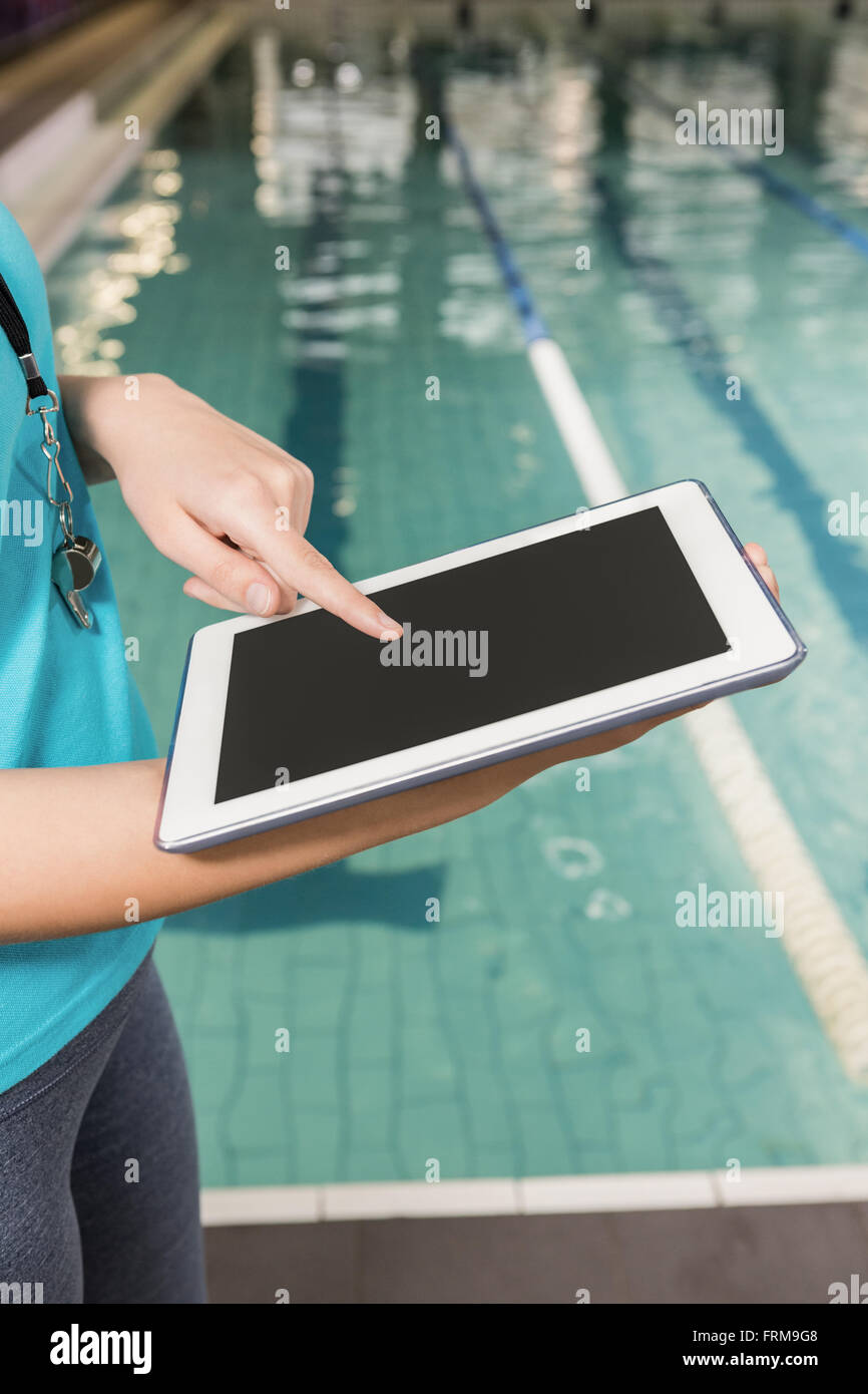 Mid section of coach using digital tablet by pool side Stock Photo