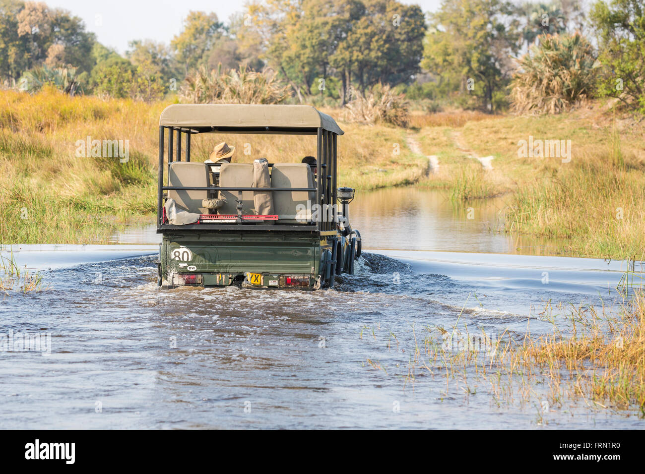 Safari 4wd jeep crossing a river ford, Sandibe Camp, by the Moremi Game Reserve, Okavango Delta, Botswana, southern Africa Stock Photo