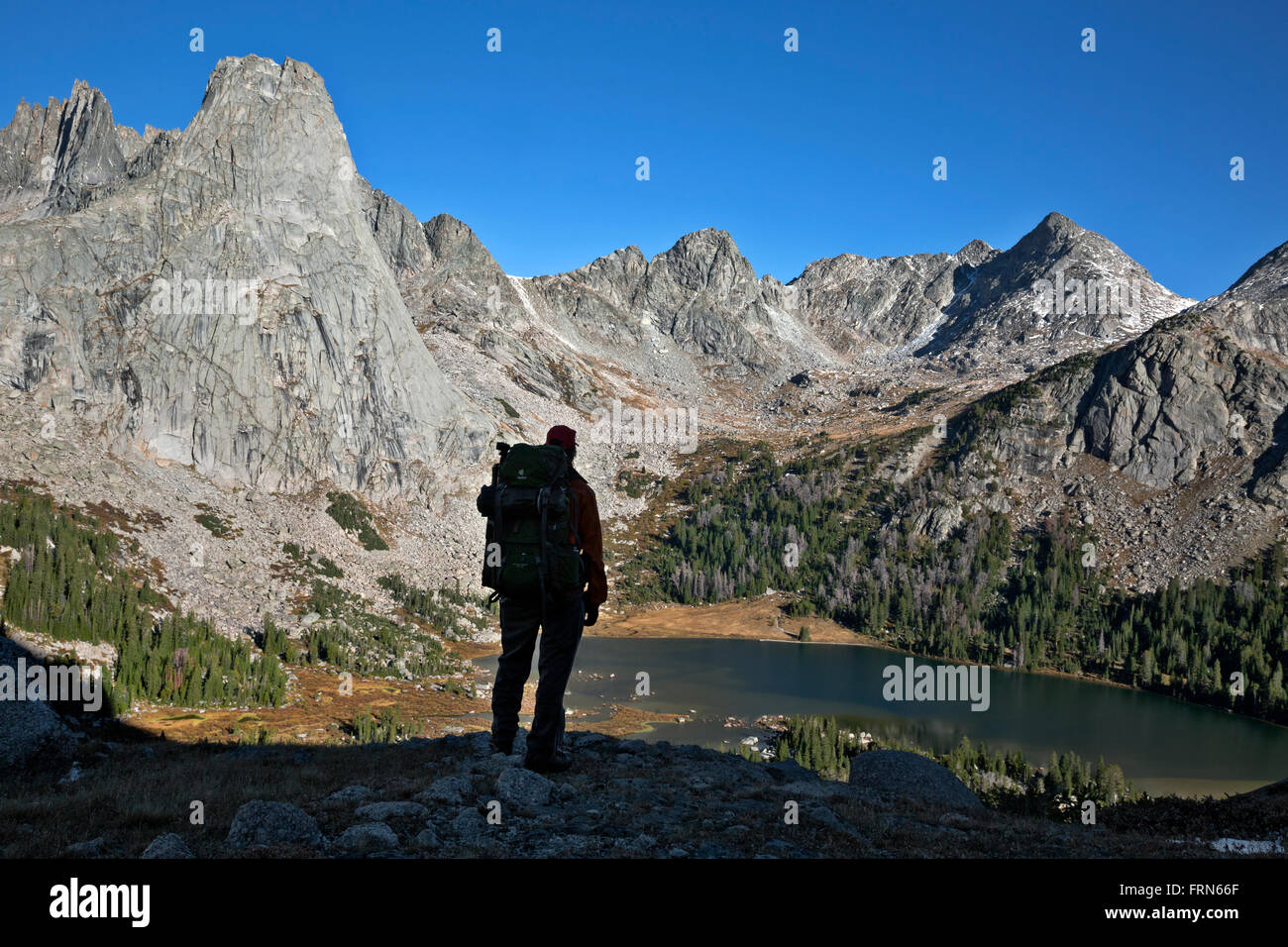 WYOMING - Hiker on Big Sandy Pass Trail overlooking Lonesome Lake surrounded by the Cirque of the Towers in Wind River Range. Stock Photo