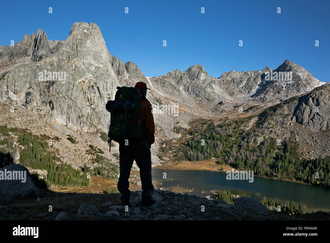 WYOMING - Hiker on Big Sandy Pass Trail overlooking Lonesome Lake surrounded by Cirque of the Towers in the Wind River Range. Stock Photo