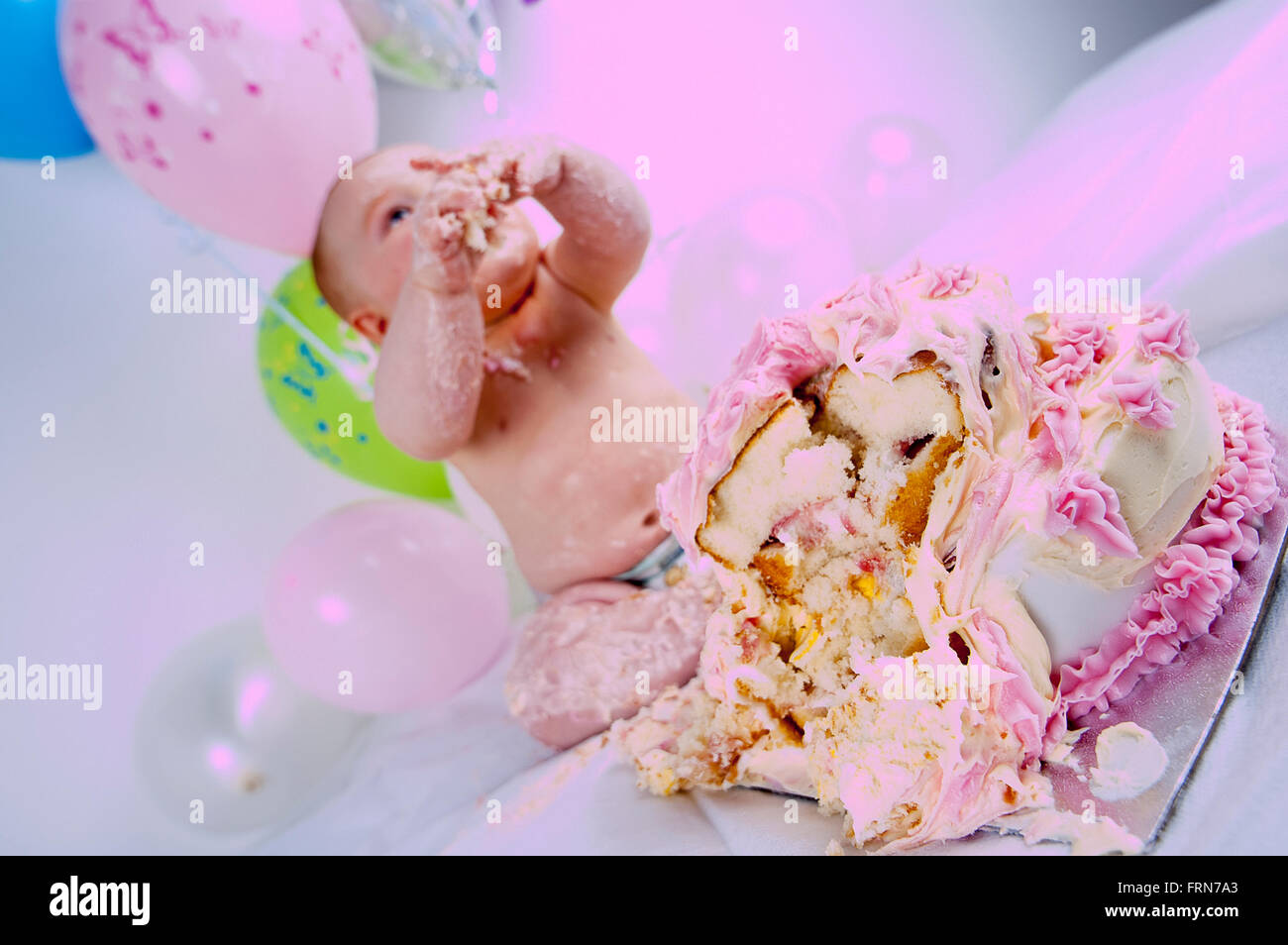 A baby smashing and eating a birthday cake Stock Photo