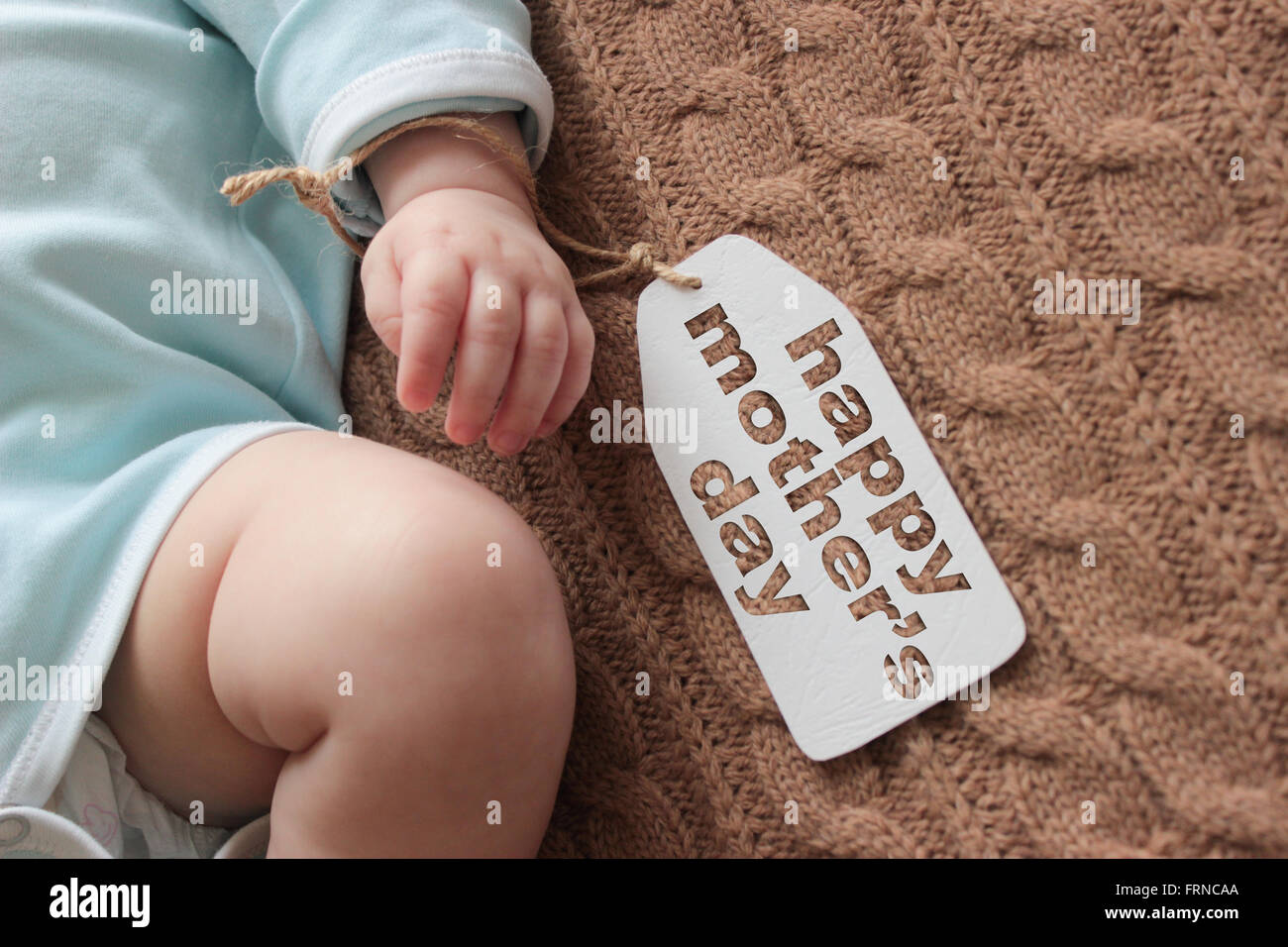 Newborn baby hand on knitted background, mother's day concept Stock Photo