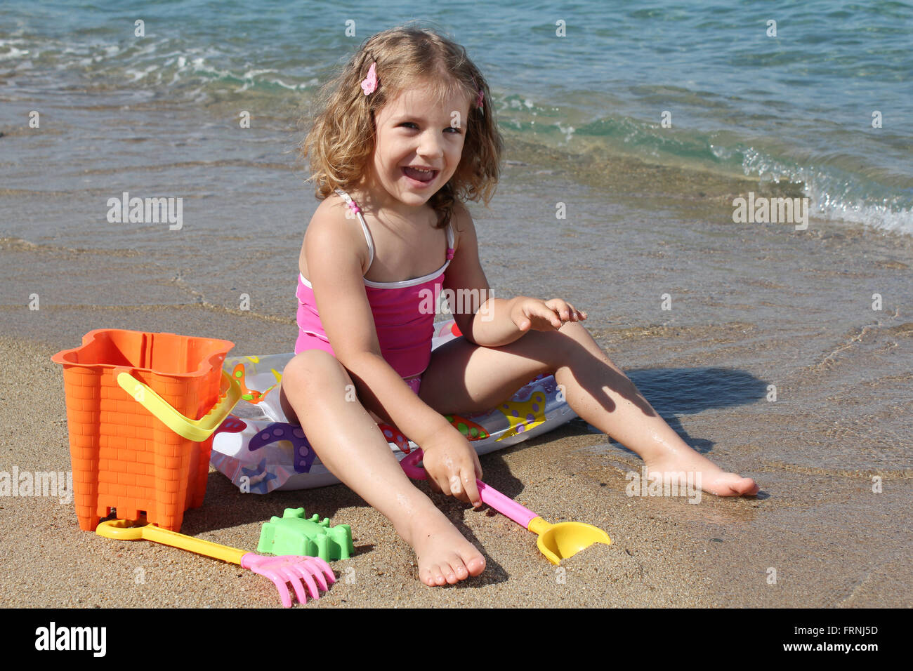 happy little girl playing on beach Stock Photo Alamy