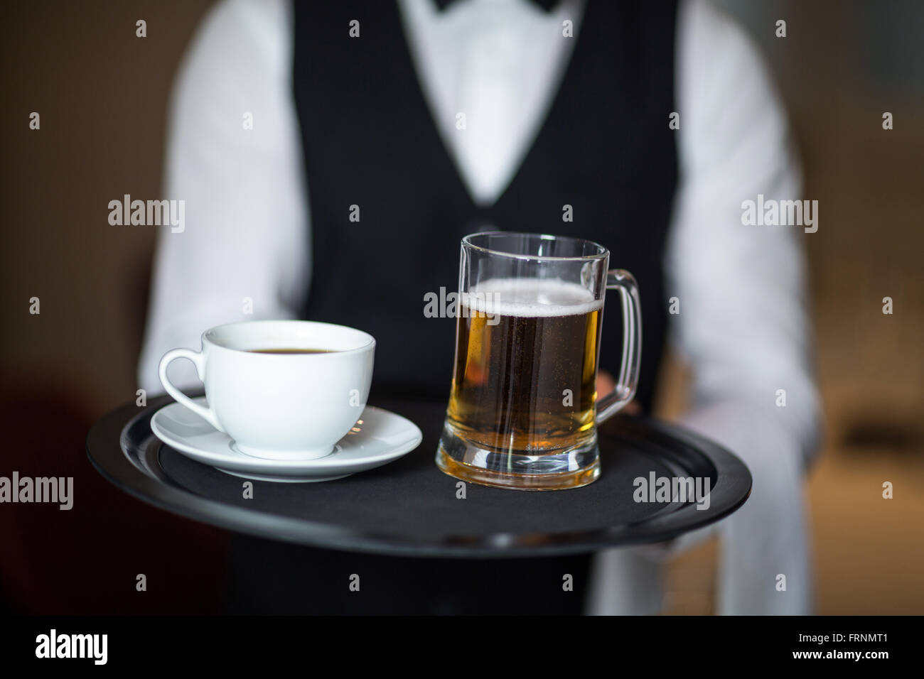 Waiter holding tray with beer Stock Photo - Alamy