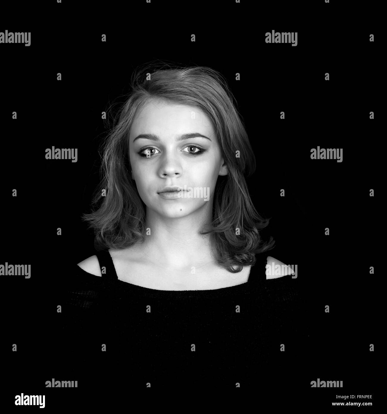 Black and white portrait of beautiful teenage Caucasian blond girl over black background Stock Photo