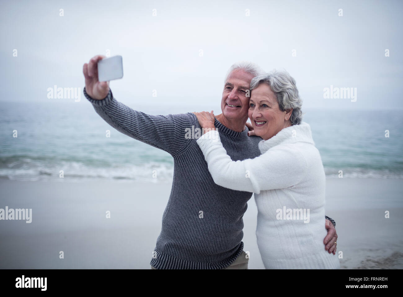 Senior couple taking a selfie on the beach Stock Photo