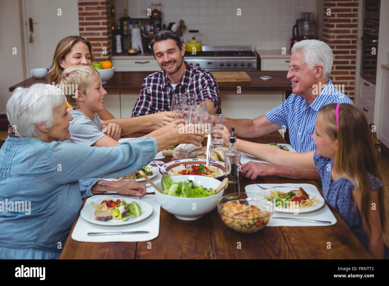 Multi generation family toasting drink while celebrating thanksgiving Stock Photo