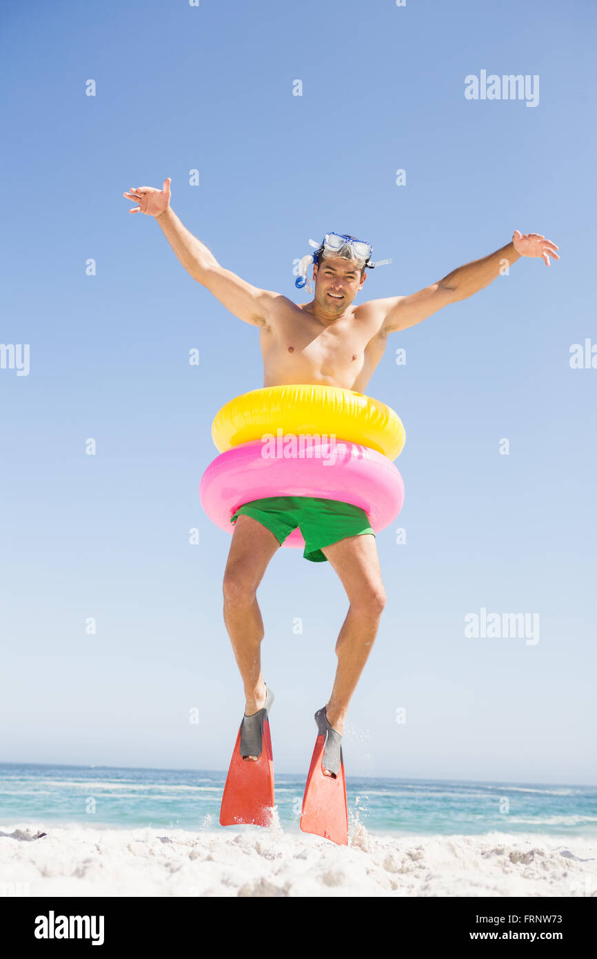 Smiling man jumping with rubber ring Stock Photo