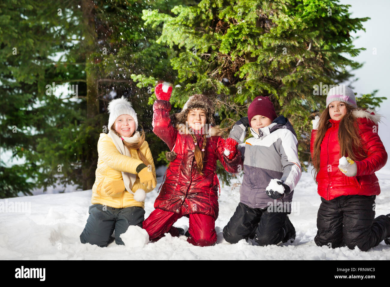 Happy friends playing snowballs at winter forest Stock Photo - Alamy