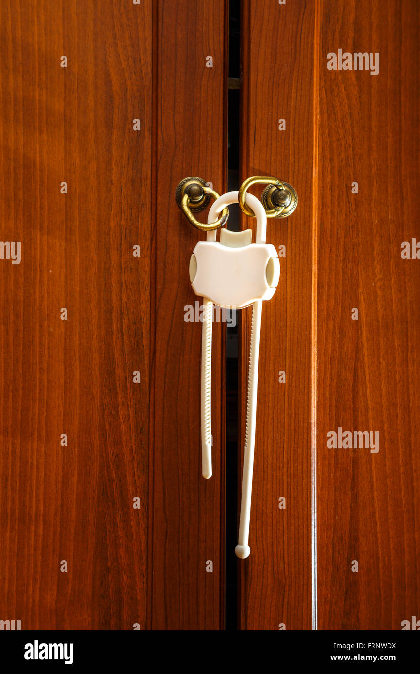 Safety plastic lock for kid protection on wardrobe Stock Photo