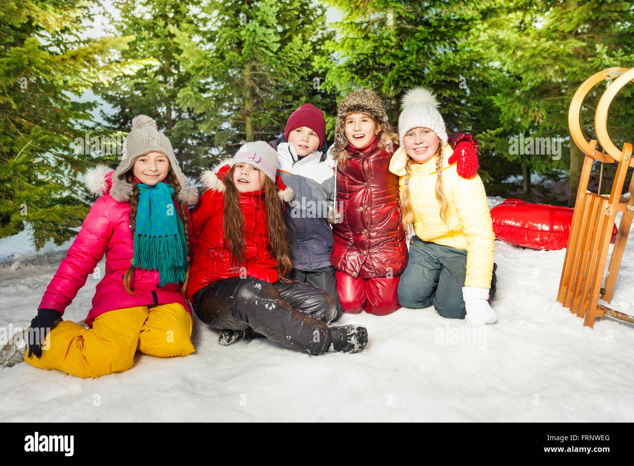 Group of children sitting on snow in winter time Stock Photo - Alamy