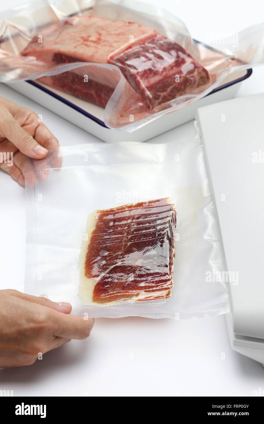 preserving fresh meat and raw ham in a vacuum sealer Stock Photo