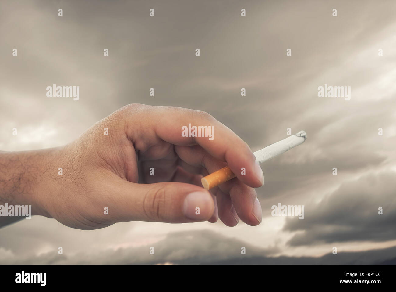 Hand Holding Cigarette While Smoking Stock Photo