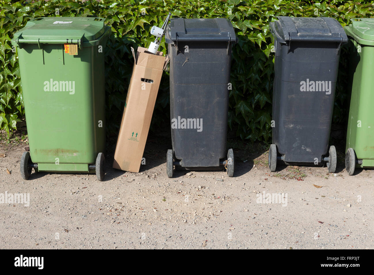 Assorted waste containers on the road side. Bins buckets and bags stand