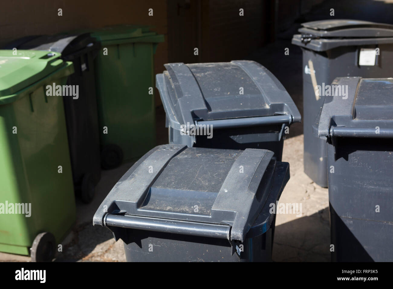 Assorted waste containers on the road side. Bins buckets and bags stand