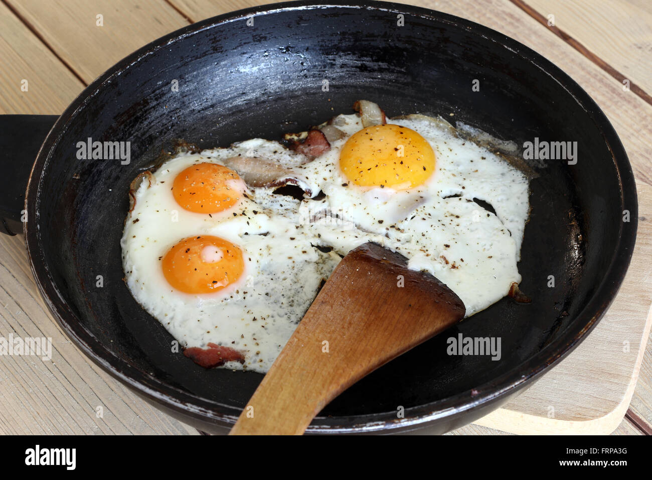 Fried eggs with bacon on the pan - a hearty breakfast - home cooking Stock Photo