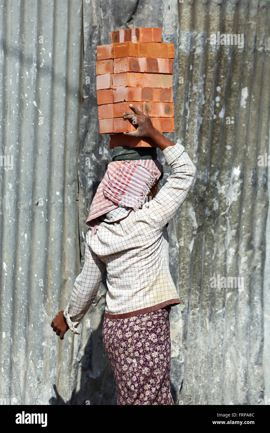 Woman carrying bricks on her head on a building site in Amarapura, Mandalay, Myanmar (Burma) Stock Photo
