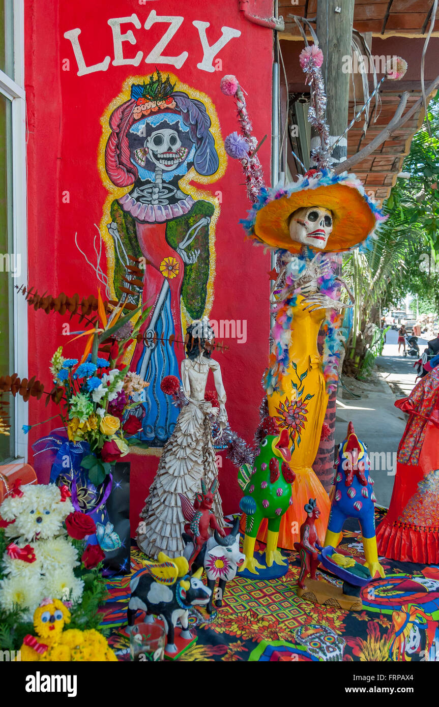 Dia de Los Muertos Day of the Dead figures of La Catrina w/ colorful mural + crafts displayed outside shop in Sayulita, Mexico. Stock Photo