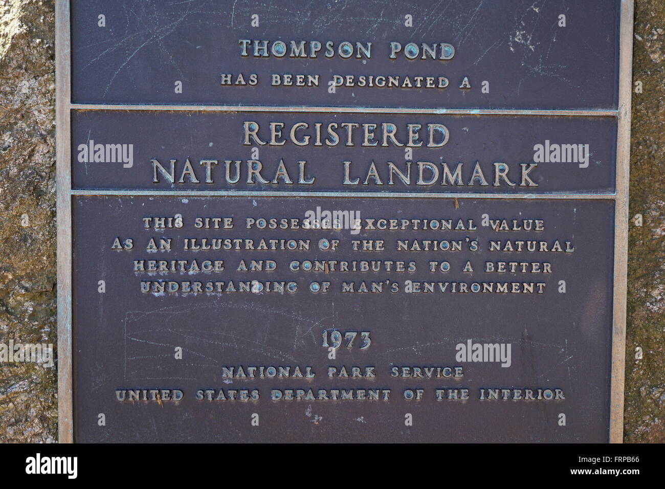 A metal plaque, that designates Thompson Pond as a registered natural landmark. Stock Photo