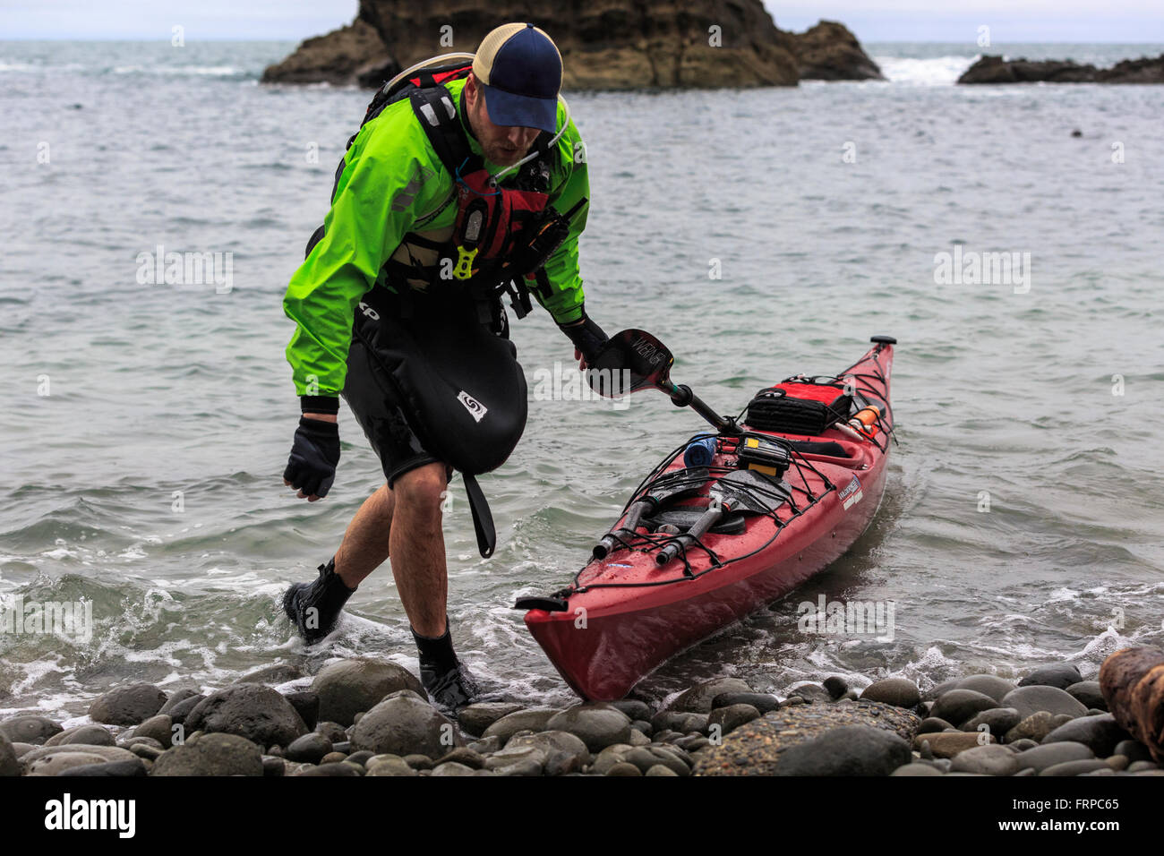 Kayaker pulls kayak into rocky Oregon coast Stock Photo Alamy