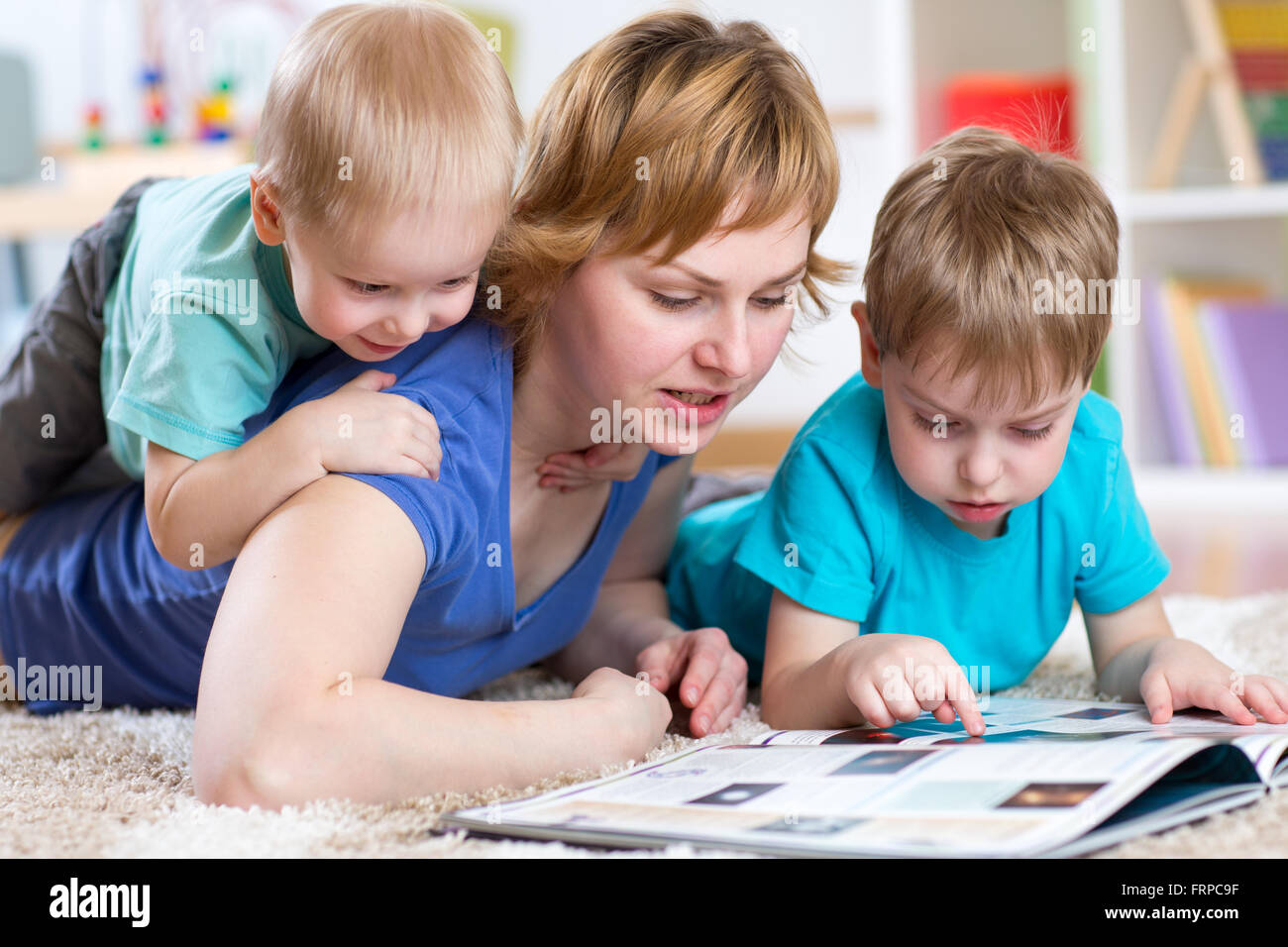 Mother and kids reading book at home Stock Photo