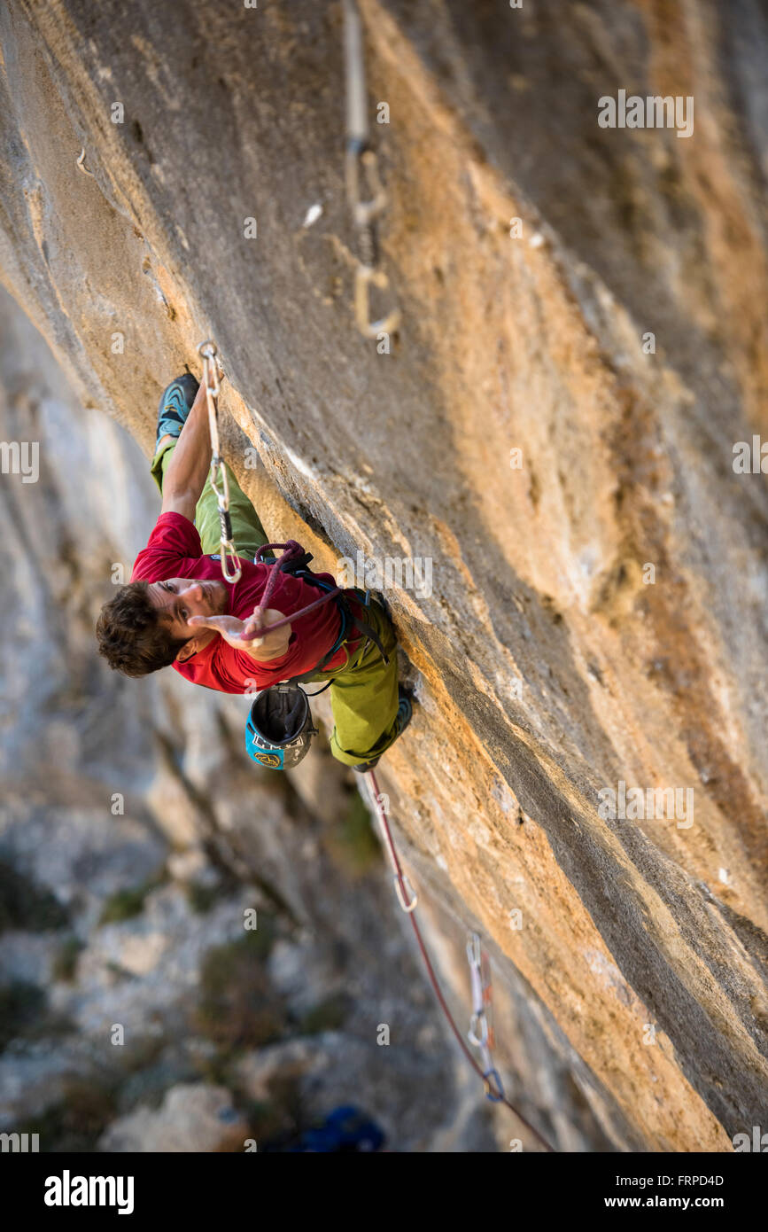 Man climbing an hard granite sport route in Andonno, CN, Italy. Stock Photo