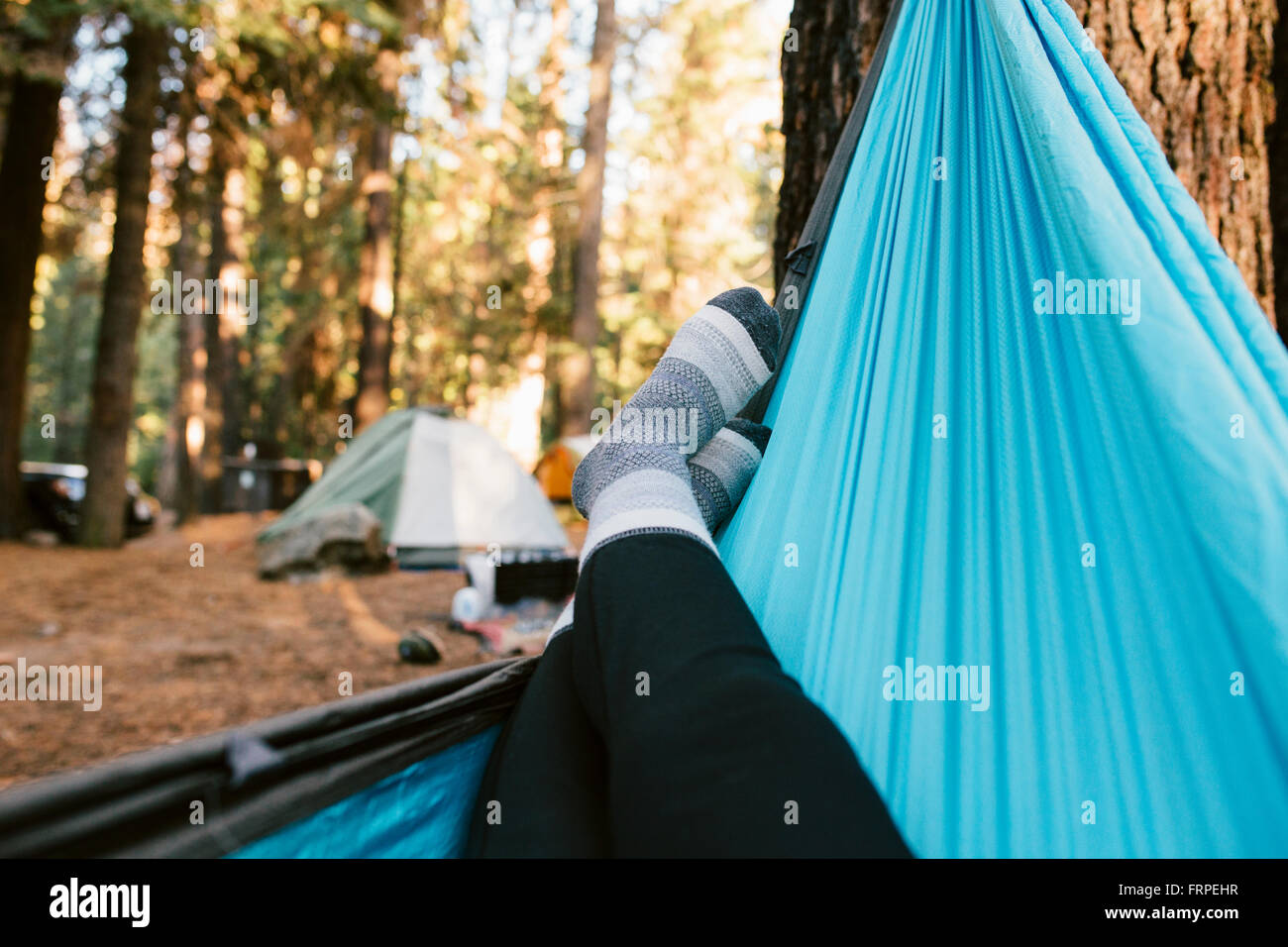 A woman relaxing in a hammock at a campground in Yosemite Stock Photo