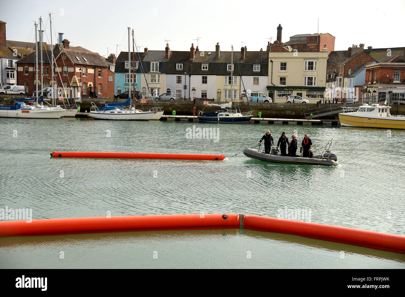 Oil pollution containment boom deployment exercise at Weymouth Harbour, Dorset, UK Stock Photo