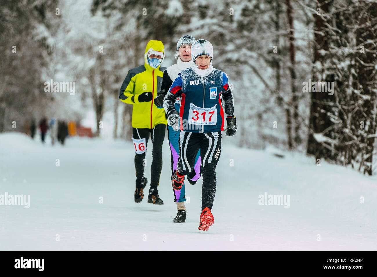 group of leading athletes runners in winter forest, cold weather during