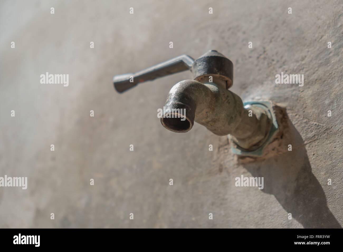 old faucet on concrete wall, save the water concept Stock Photo