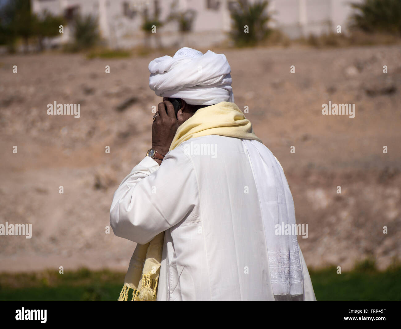 Arab man using mobile phone in the desert oasis Stock Photo - Alamy