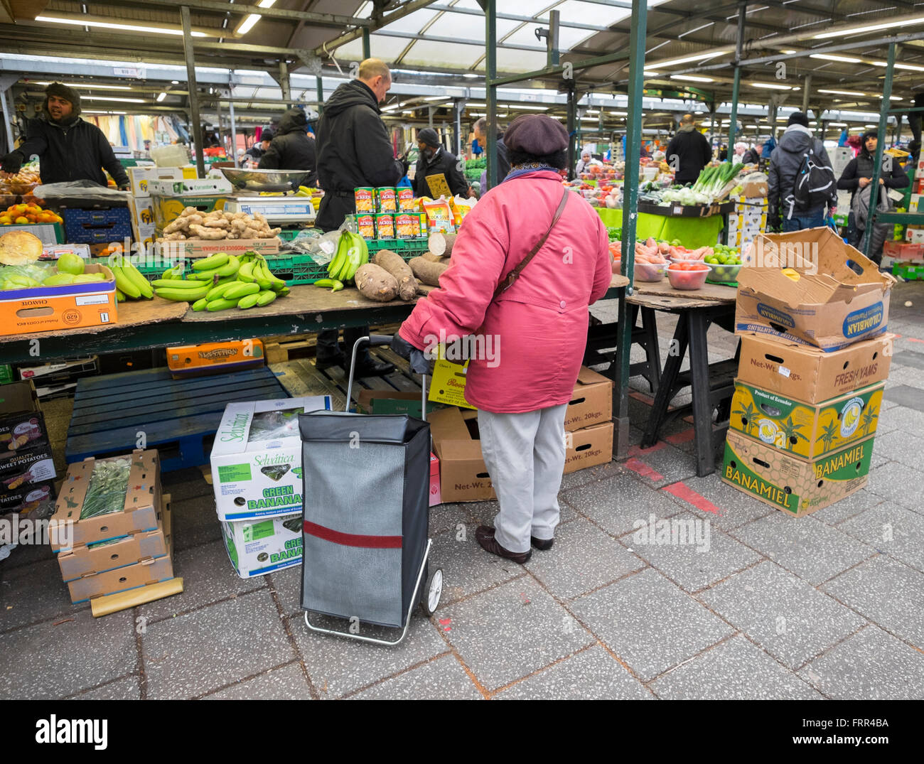 A customer waits at a fruit and vegetable stall in Birmingham outdoor