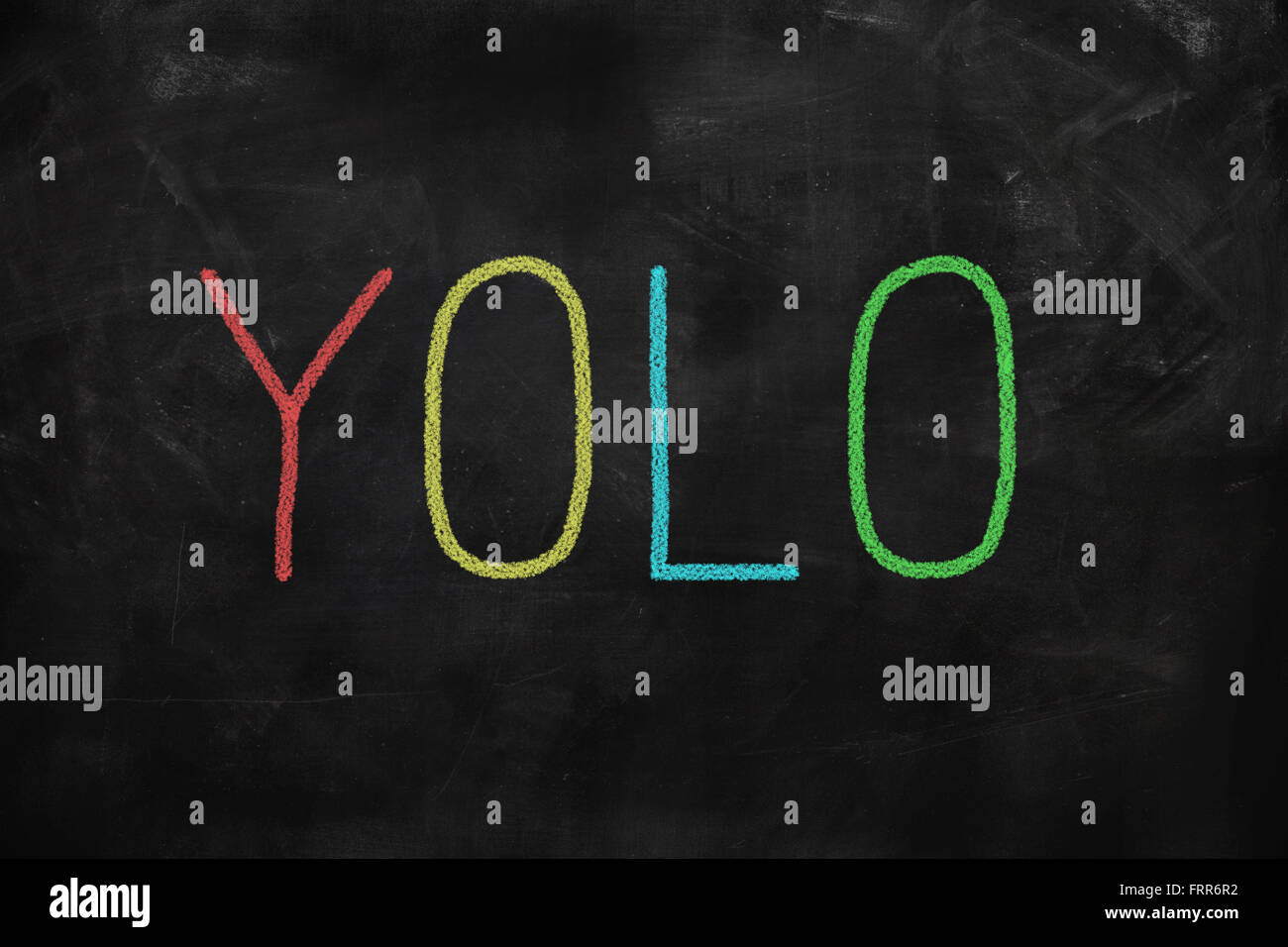 You Only Live Once yolo written on a blackboard Stock Photo