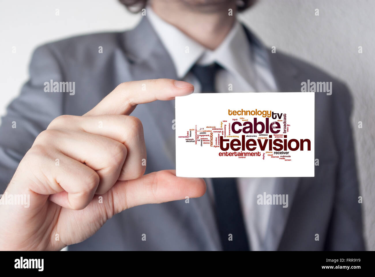 Cable television. Businessman in suit with a black tie showing or holding business card Stock Photo